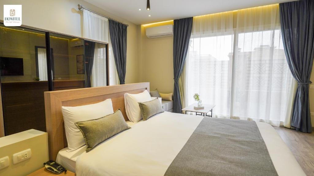 Postel nebo postele na pokoji v ubytování Homtel Residence West Golf - Kattamya