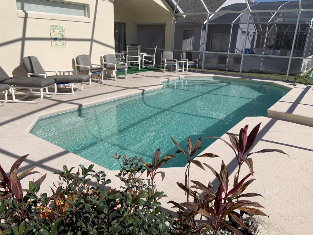 una piscina con sedie, tavolo e sedie di Ideal Location On A Golf Complex a Haines City