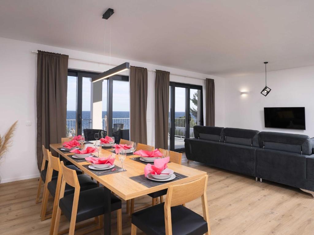a dining room with a table and a couch at Sunlit Shores Beach Villa with Pool, Gym and Sauna - Three Bedroom Villa with Pool in Jelsa