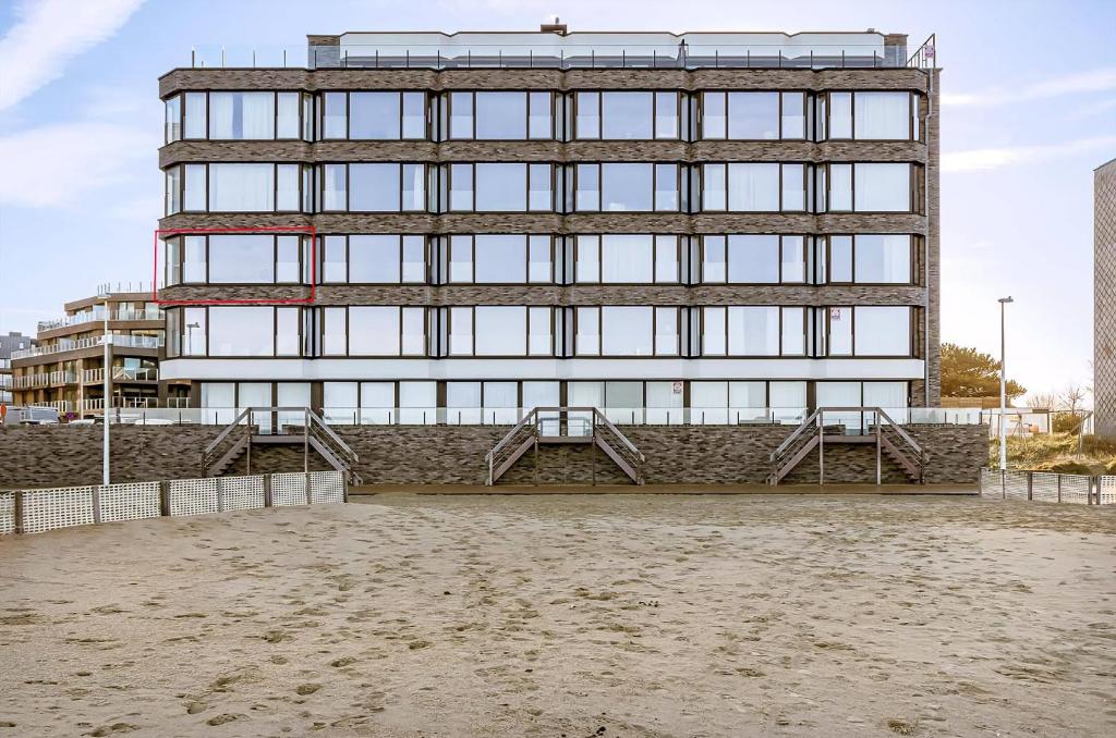 a tall building with glass windows on a beach at Idesende 2-0203 P in Sint-Idesbald