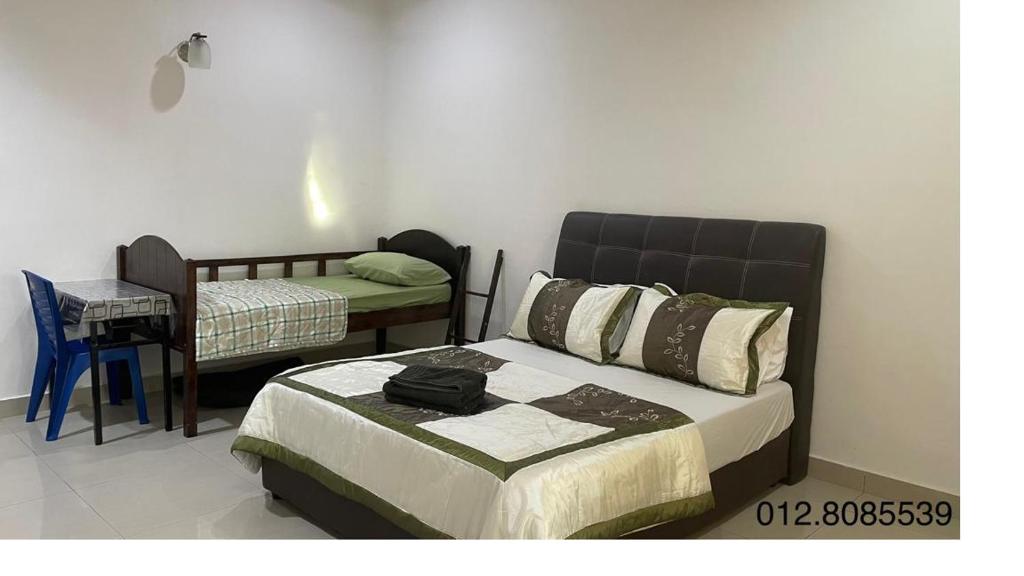 a bedroom with a bed and a table and a chair at Tanmu EH in Batu Pahat