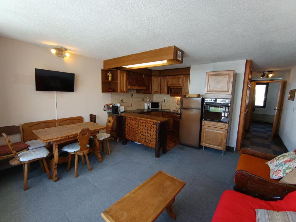 une cuisine avec une table et une salle à manger dans l'établissement Appartement face aux pistes - Animaux acceptés - FR-1-445-222, à Montgenèvre