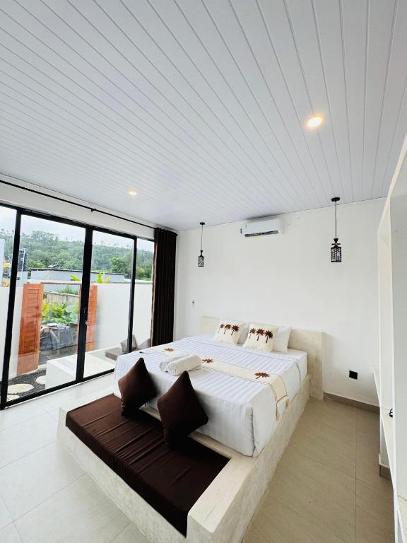 a bedroom with a large bed and a large window at Brahmastra Bali villa in Kubupenlokan
