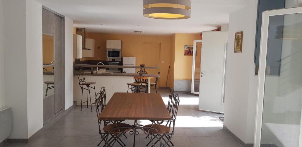a kitchen and dining room with a table and chairs at Maison entière garage à 5 minute à pied des grands buffets et centre ville in Narbonne