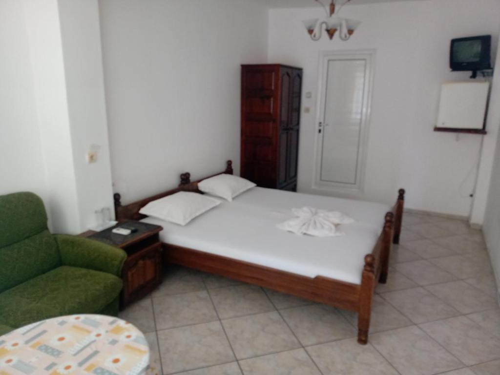 a bedroom with a bed and a green chair at Guest House Diamant in Sozopol