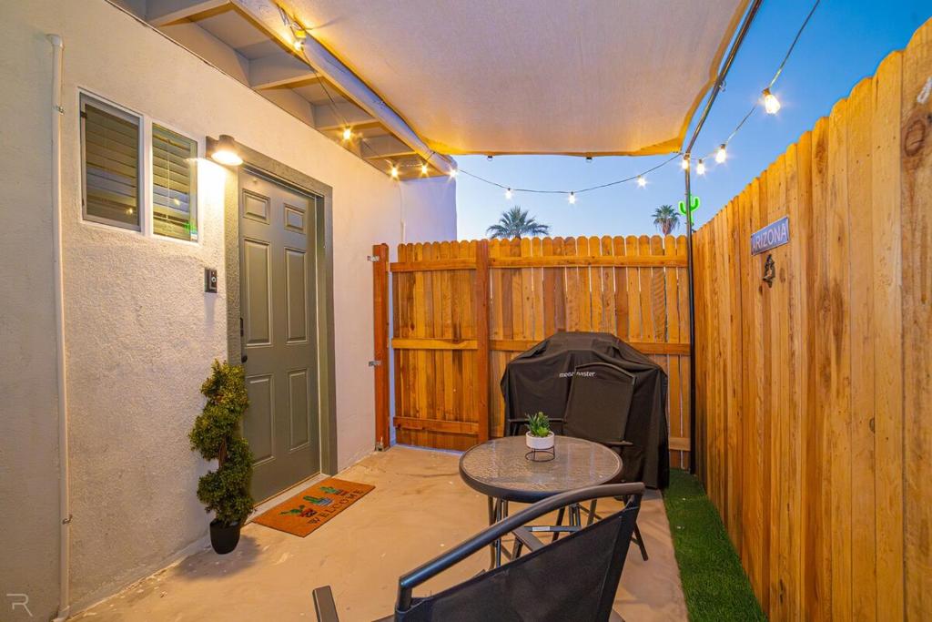 a patio with a table and a wooden fence at Cactus Cottage in Yuma