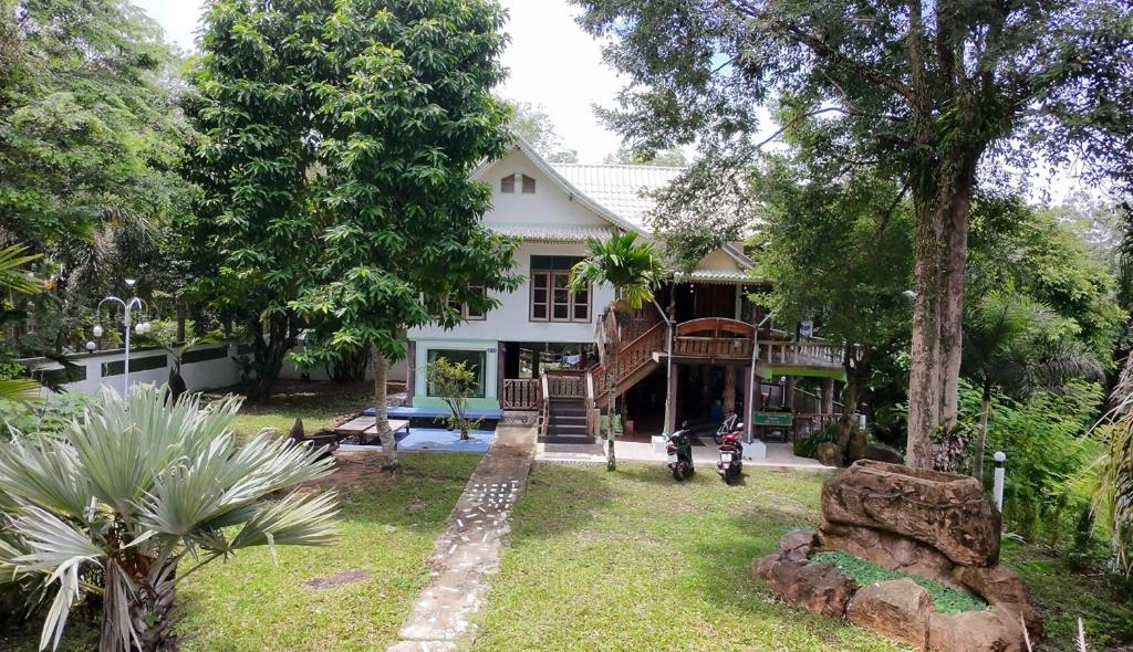 a house with a motorcycle parked in front of it at Baan Nara Homestay - Koh Kood in Ko Kood