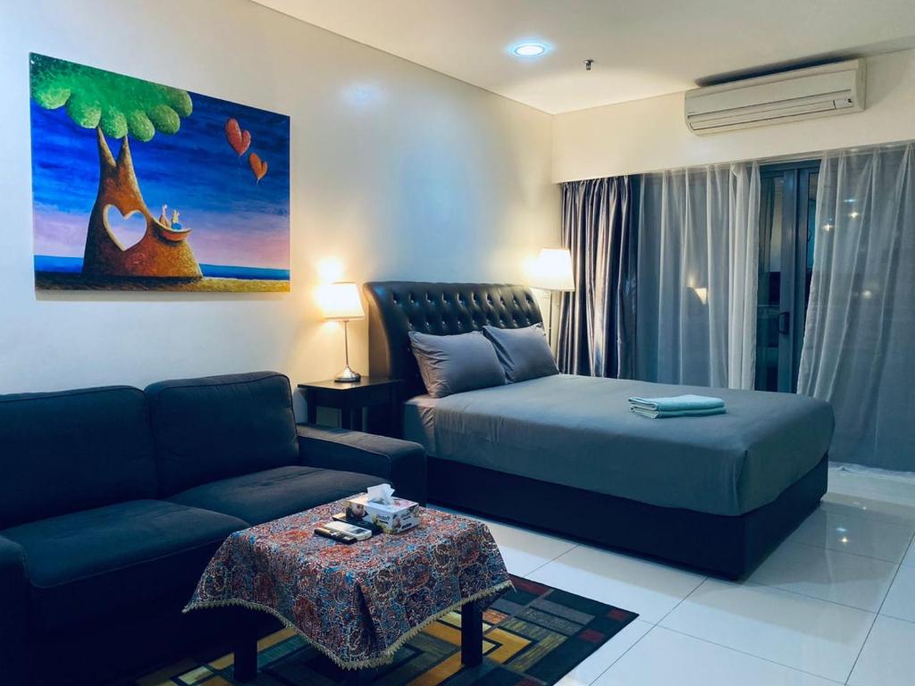 吉隆坡Summer Suites KLCC by CozyNest的客厅配有床和沙发