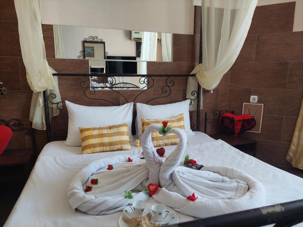 Dos cisnes hechos de toallas en una cama en Paralax Hotel, en Varna