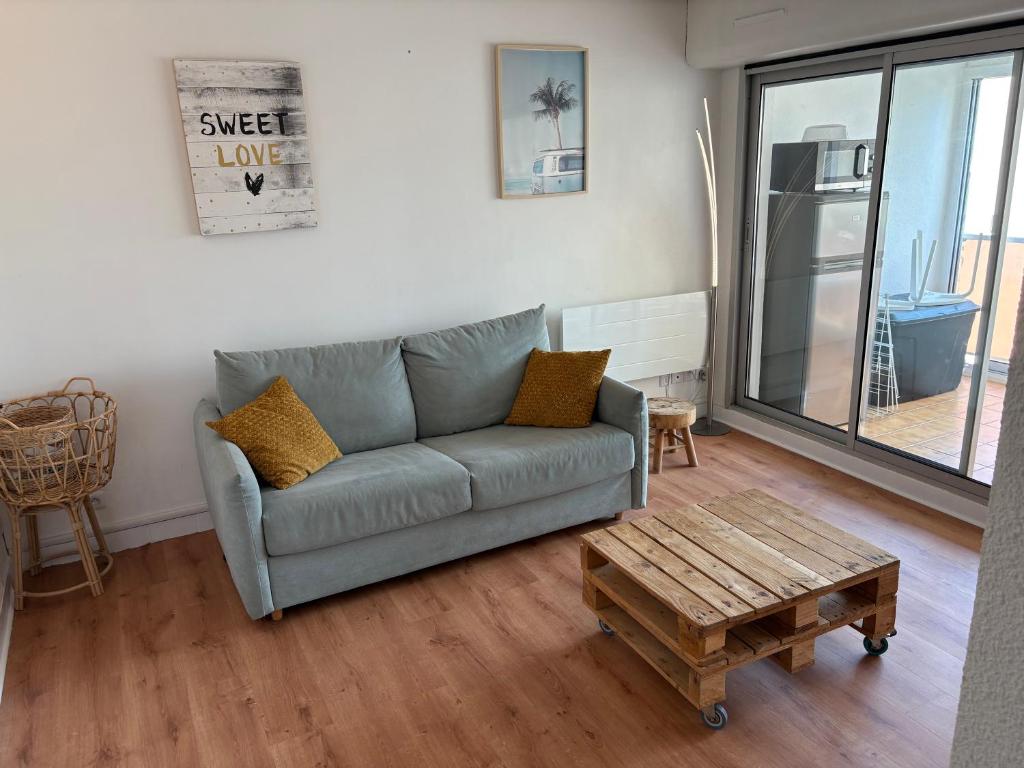 un salon avec un canapé et une table basse dans l'établissement HELiOS, au Cap d'Agde