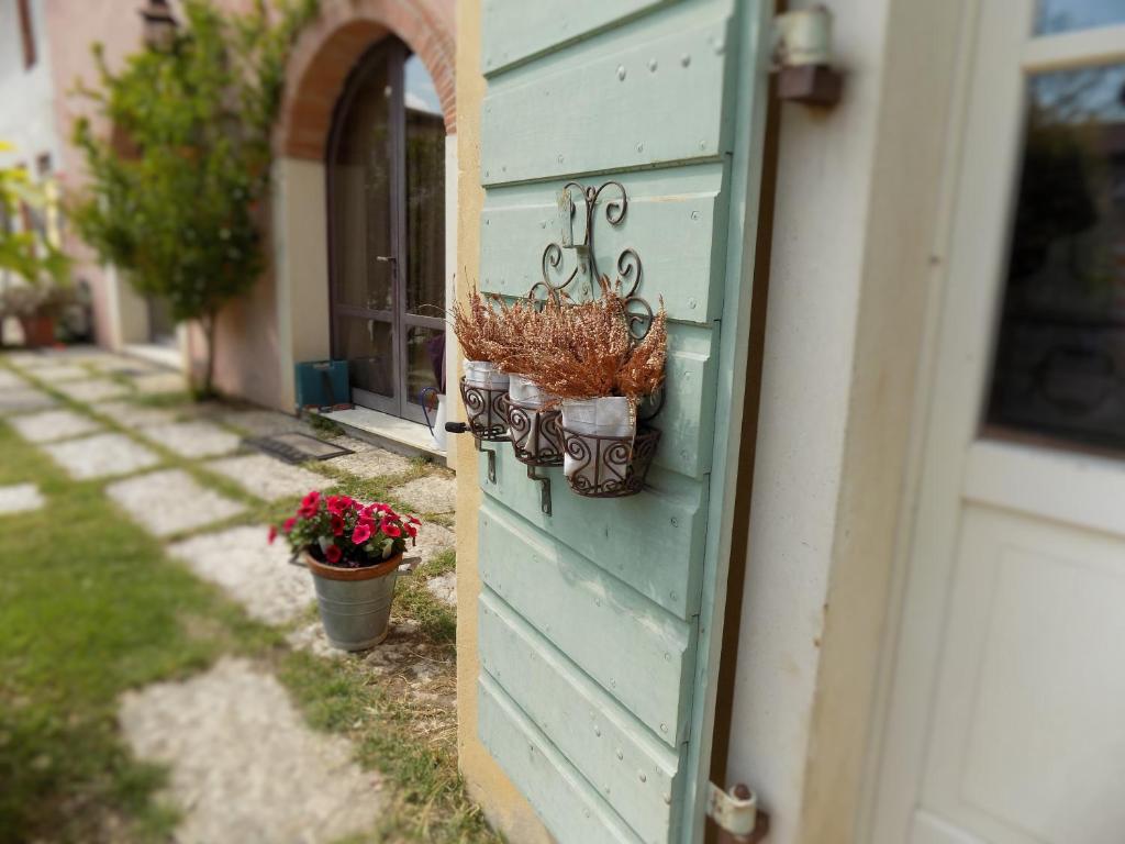 a blue door with two potted plants on the side of a house at Due Archi in SantʼAmbrogio di Valpolicella