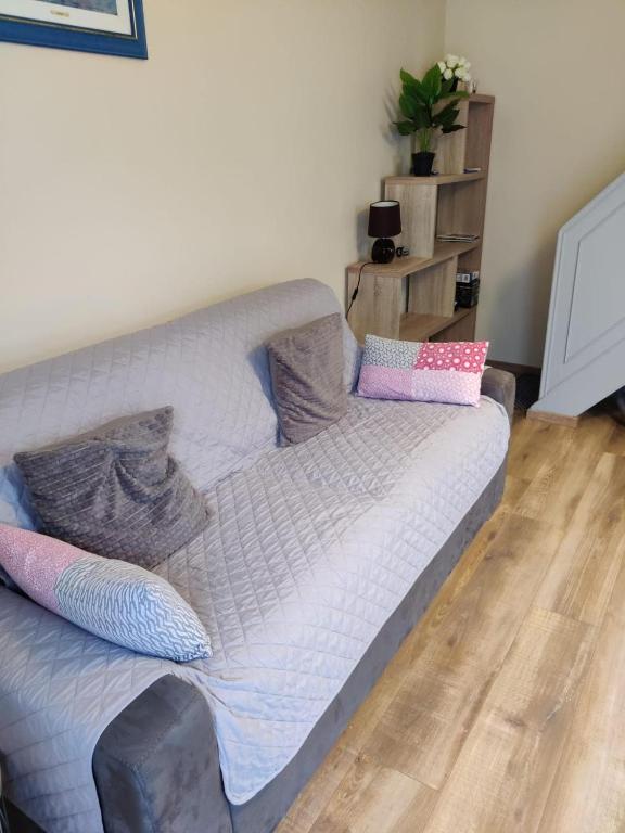 - un canapé dans le salon avec des oreillers dans l'établissement Maisonnette au pied du marché et 300 m de la plage, à Saint-Georges-de-Didonne