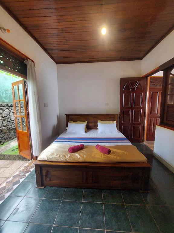 a bedroom with a bed with two red shoes on it at Mystique Hideout in Kandy