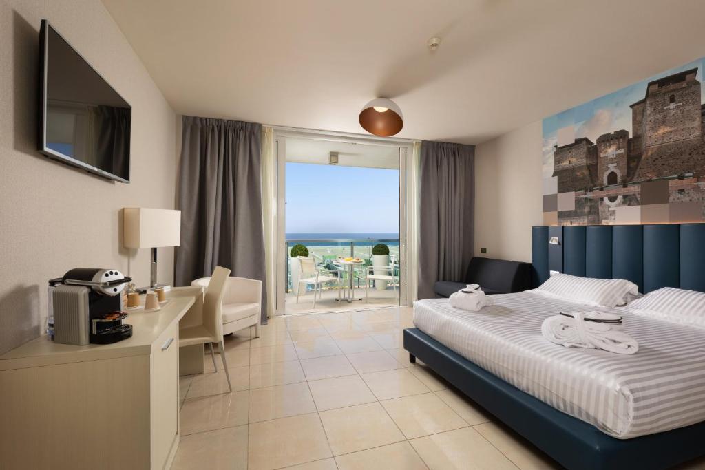 una camera d'albergo con un letto e vista sull'oceano di Mercure Hotel Rimini Artis a Rimini