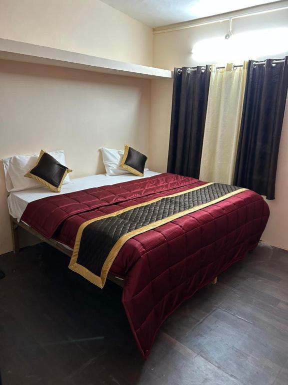 Un dormitorio con una cama grande con una manta roja. en Vel Home Stay, en Kodaikanal