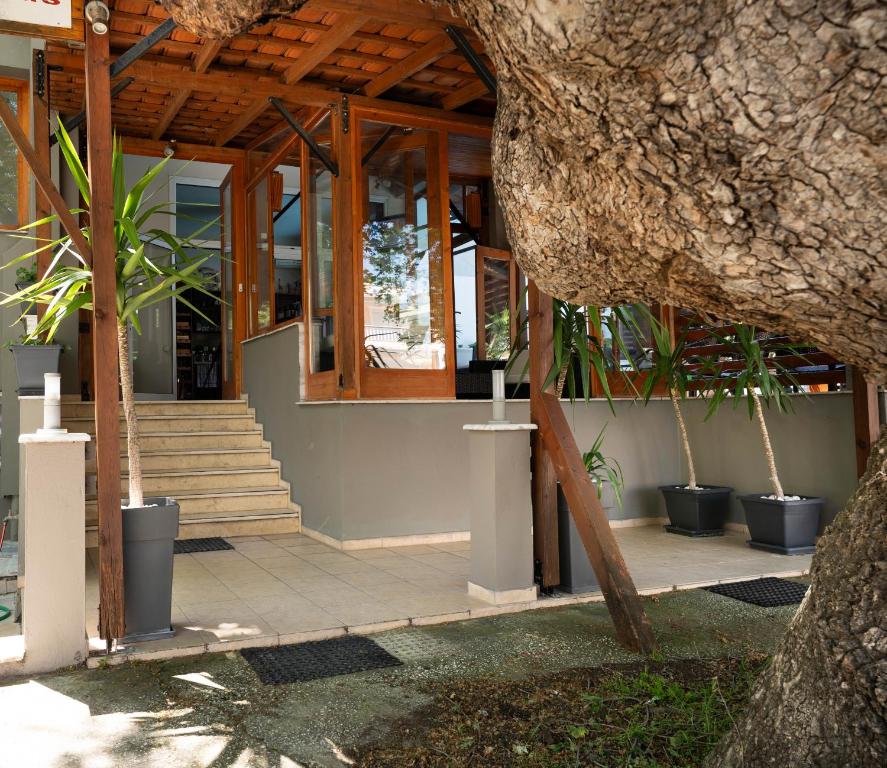 a building with a wooden roof and some plants at Kipos Resort in Nea Peramos