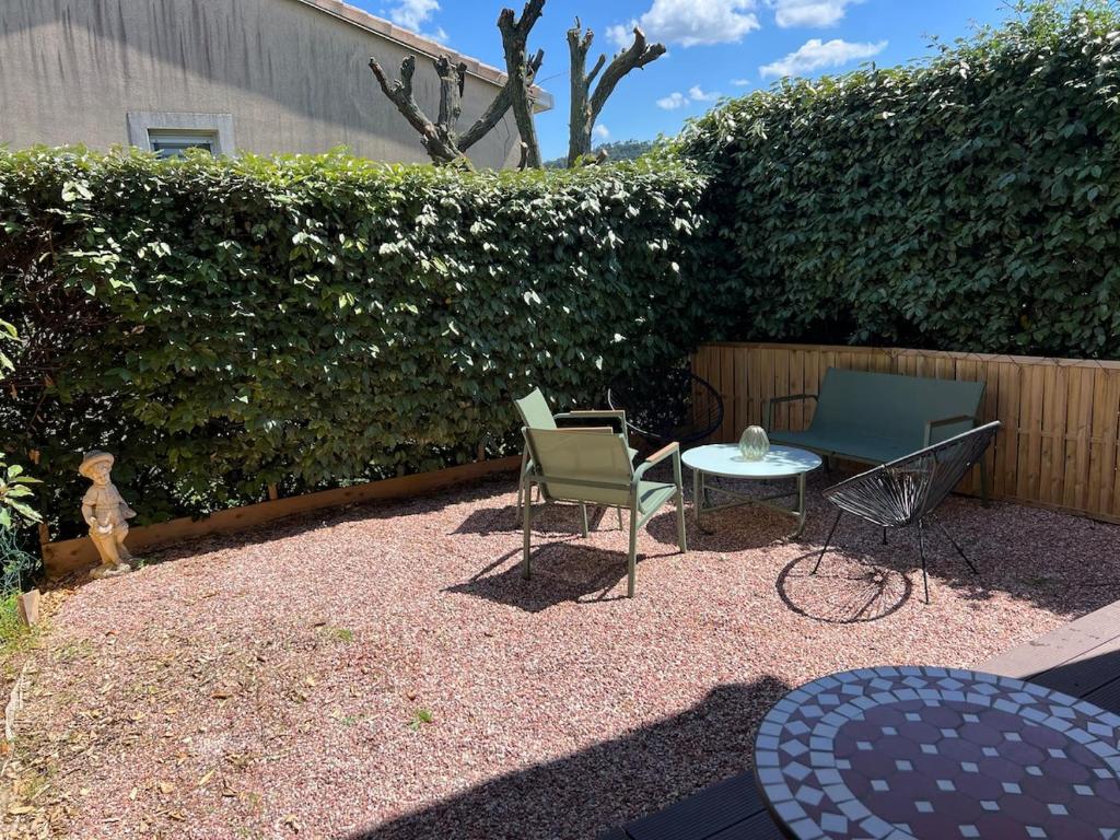une terrasse avec des chaises, une table et une haie dans l'établissement Appartement vue château, à Carcassonne