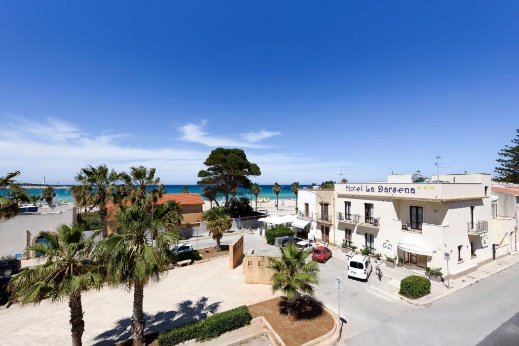 an aerial view of a town with palm trees and the ocean at Hotel La Darsena in San Vito lo Capo