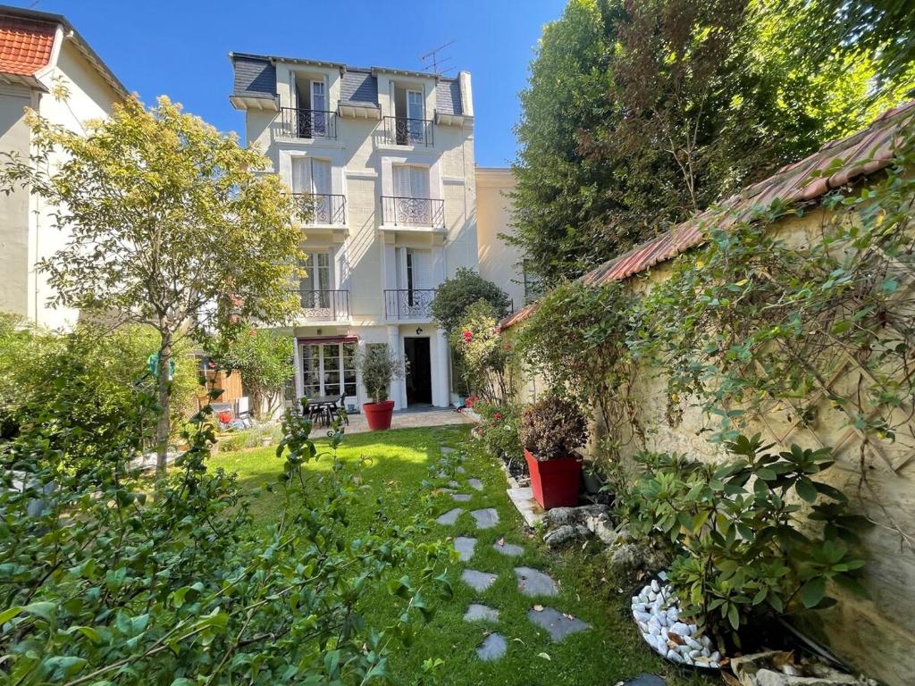 un immeuble d'appartements avec une cour avec des plantes dans l'établissement Large duplex, quiet garden, in private mansion, à Neuilly-sur-Seine