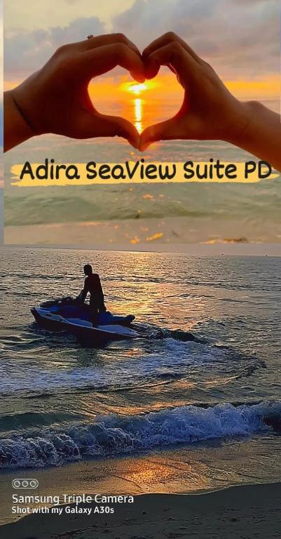 a person on a paddle board in the water with a heart at Adira Corus Paradise Seaview Family Suite in Port Dickson