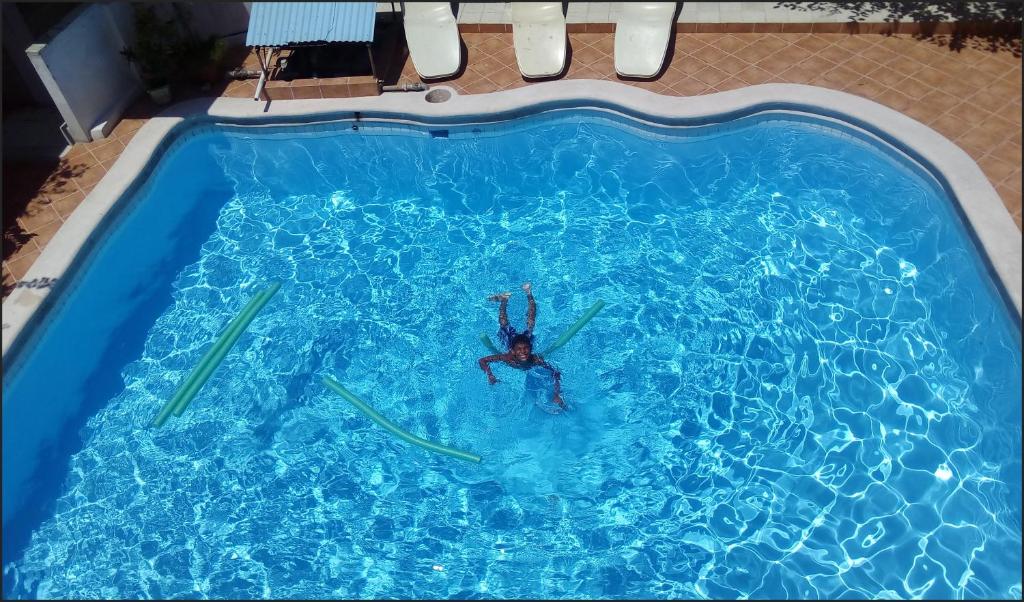 
a person in a pool swimming in a blue pool at Park Hotel in Port-au-Prince
