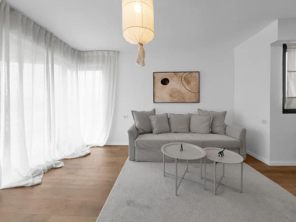 a living room with a couch and two tables at Ritzside Marina Stay in Herzliya B