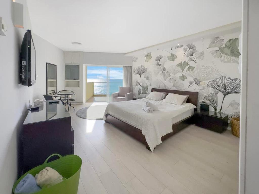a bedroom with a large bed and a living room at The Sharon Sky Suite in Herzliya B