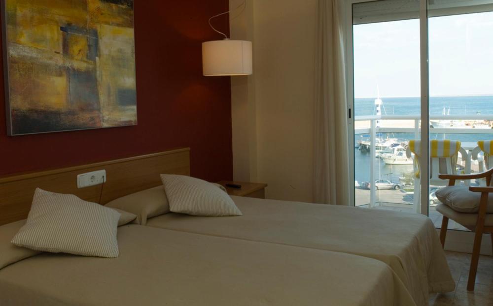 a bedroom with a bed with a view of the ocean at Hotel Roca Plana in L'Ampolla