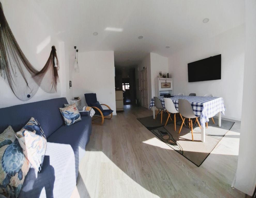 a living room with a blue couch and a table at Ferreirinhas - Beach House in Vila do Conde