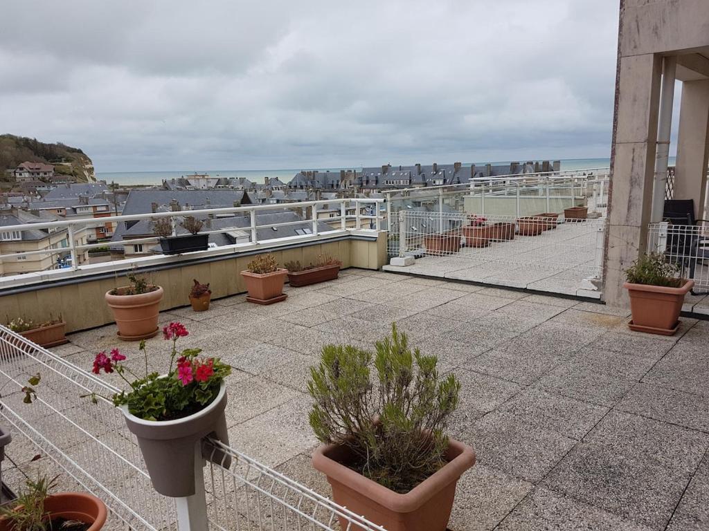 - un balcon avec des plantes en pot au-dessus d'un bâtiment dans l'établissement Studio avec terrasse vue mer, à Saint-Valery-en-Caux
