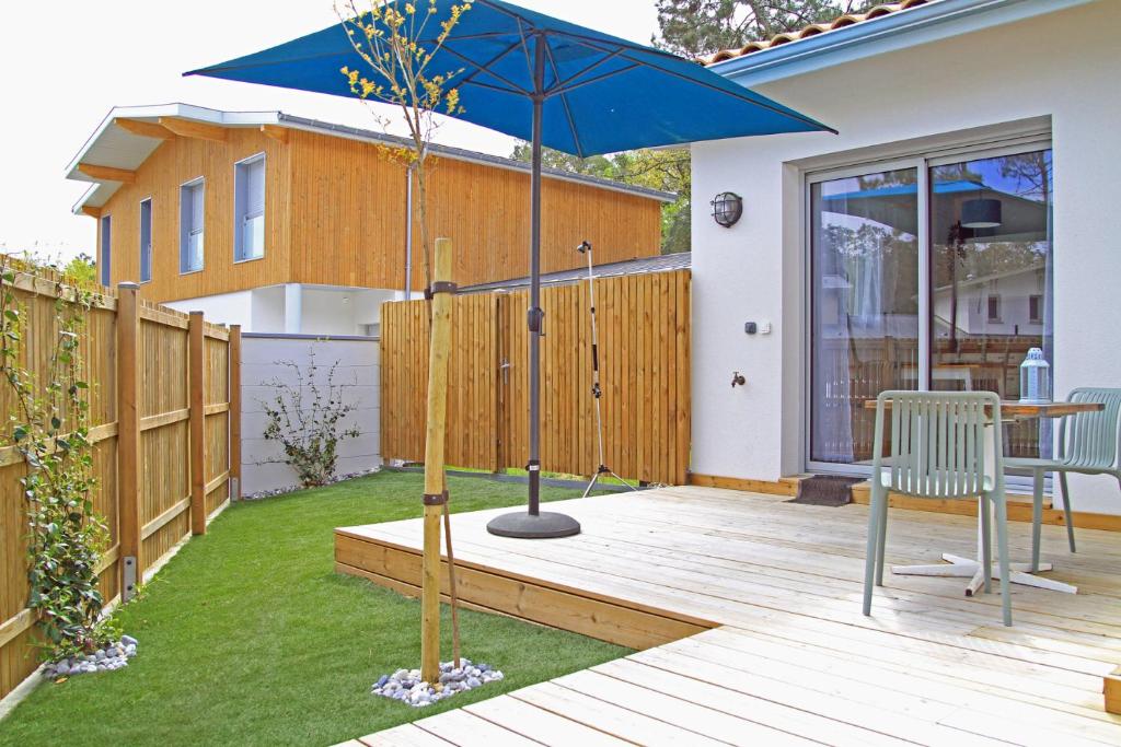 un patio avec une table et un parasol dans l'établissement New Studio 30m2 near beach with garden and terrace, à Seignosse