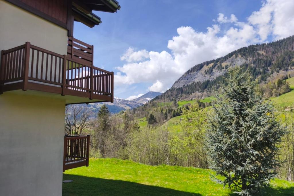 un balcon d'une maison avec vue sur les montagnes dans l'établissement Apartment with pool at the foot of the slopes, à Flumet