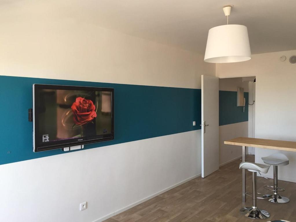 une pièce avec une télévision à écran plat sur un mur dans l'établissement Studio lumineux avec terrasse à Carnon-Plage, à Mauguio