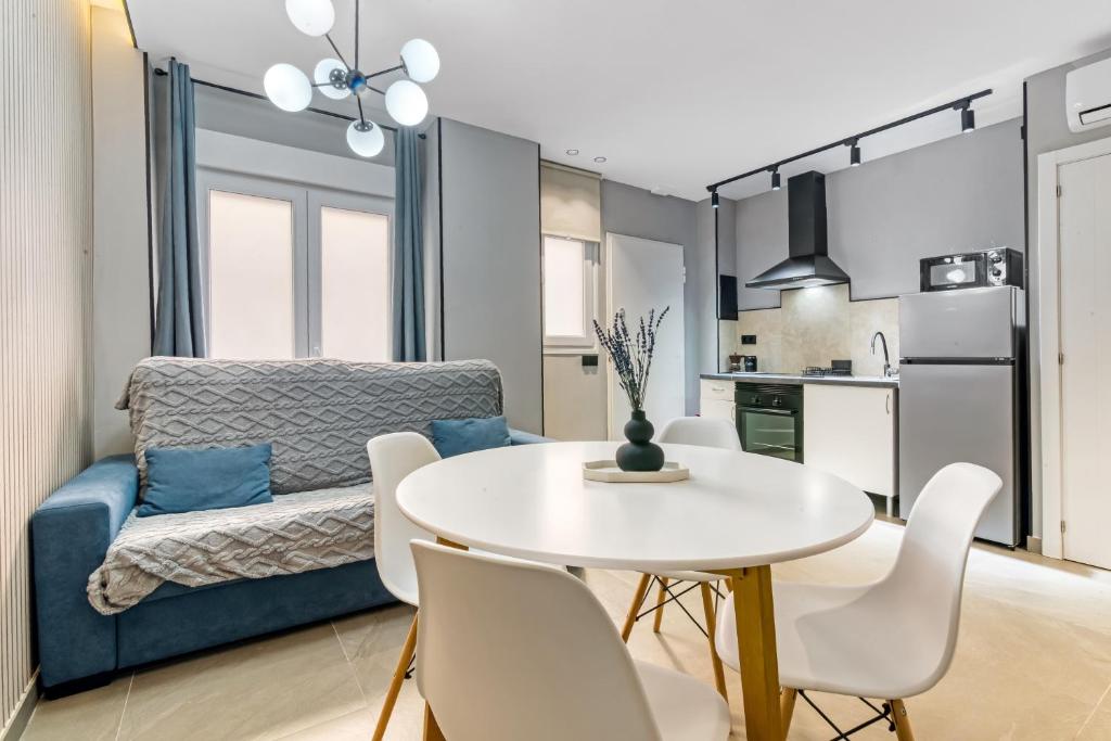 a kitchen and living room with a white table and chairs at City Suites in Valencia