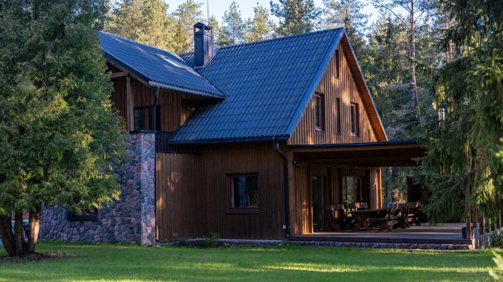 a wooden house with a blue roof at River Mind Villa with SPA in Zalioji