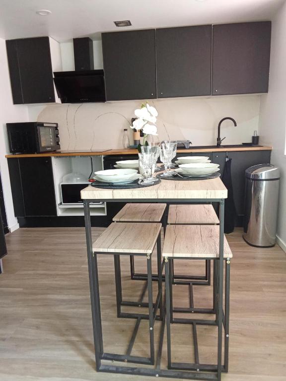 une cuisine avec une table avec deux chaises et une table et sidx sidx sidx dans l'établissement La Céliane- climatisé avec patio classé 3 étoiles, à Castelnaudary