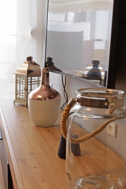 a glass jar on a wooden counter with a mirror at Kelyfos Sunset luxury apartment in Neos Marmaras