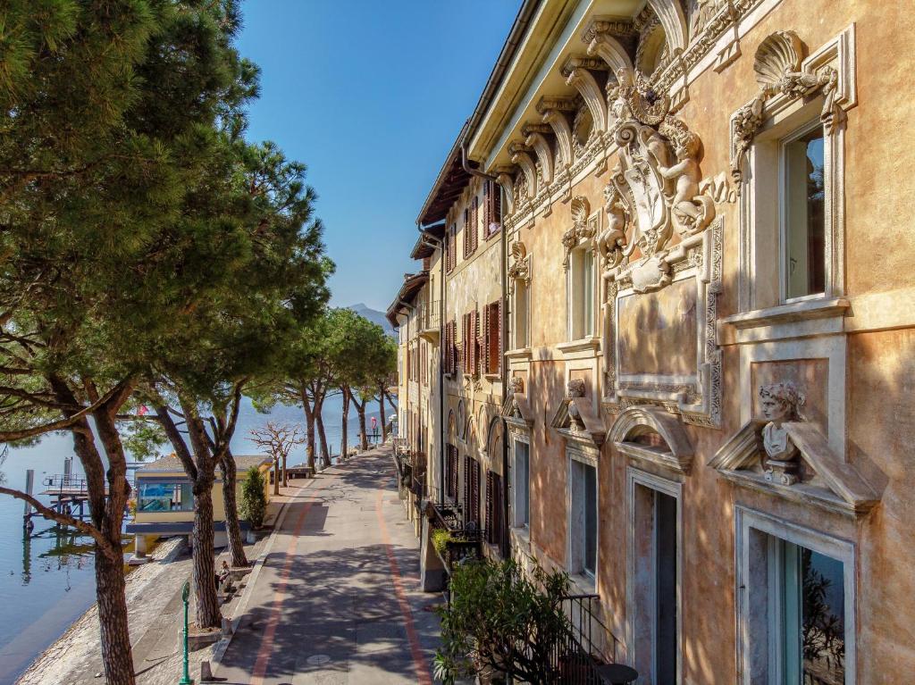 莫尔科泰Gritti Palace Morcote - Waterfront studio with panoramic lake views - Fiordaliso的水体旁街道上的建筑物