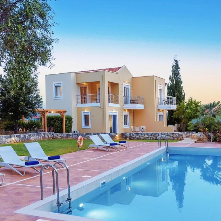a villa with a swimming pool in front of a house at Aloni Grove Retreat in Chania