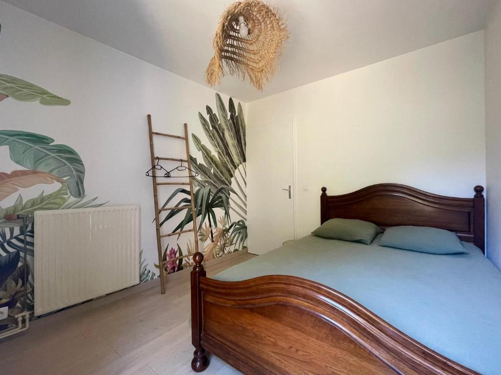 - une chambre avec un lit en bois et une plante dans l'établissement Logement indépendant avec Metro direct Paris et Orly, à Villejuif