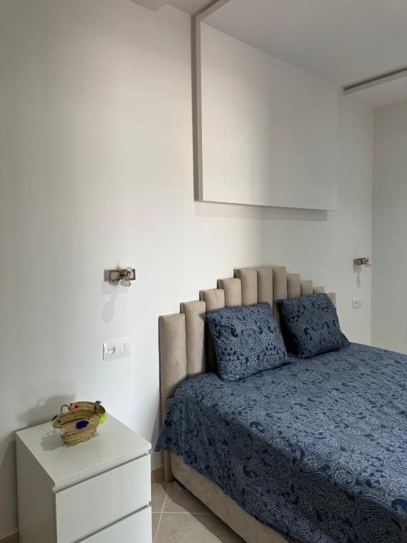 a bedroom with a bed with a blue comforter at Rimal Costa Martil in Martil