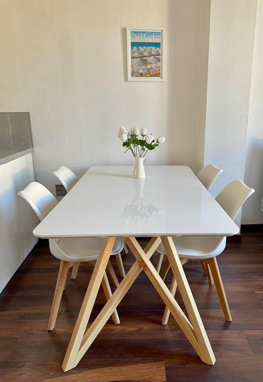 une table à manger blanche avec des fleurs blanches dans un vase dans l'établissement T2 lumineux en hyper centre, à Aix-en-Provence