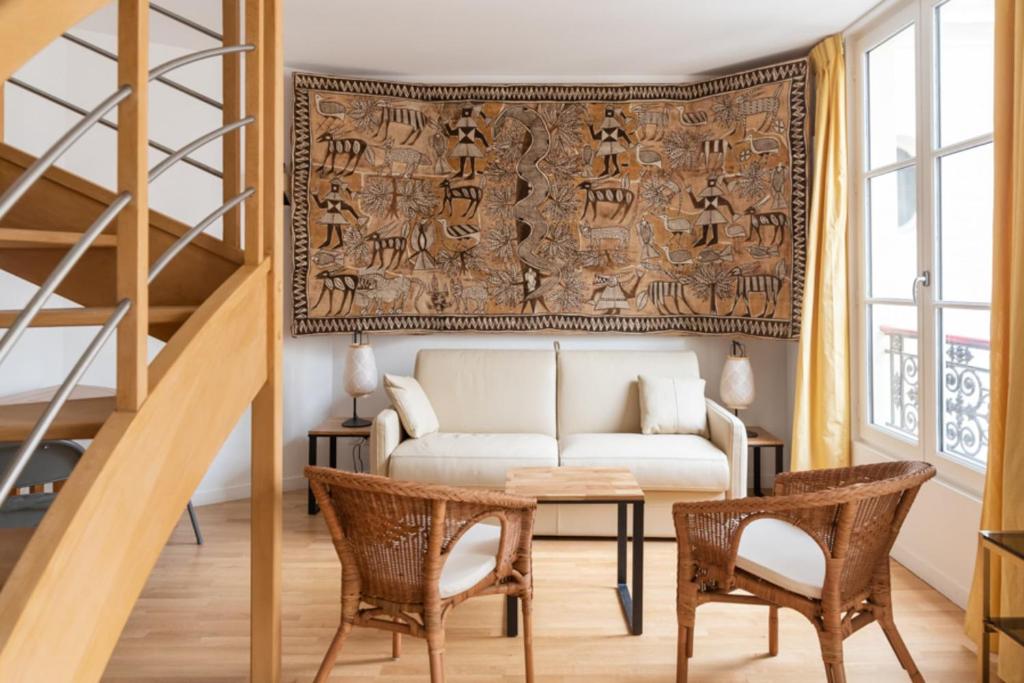 un salon avec un canapé, une table et des chaises dans l'établissement Bright & Stylish in the Heart of Le Marais, à Paris