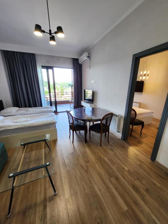 a room with a bed and a table and chairs at Seventh Floor Apartment in Kutaisi
