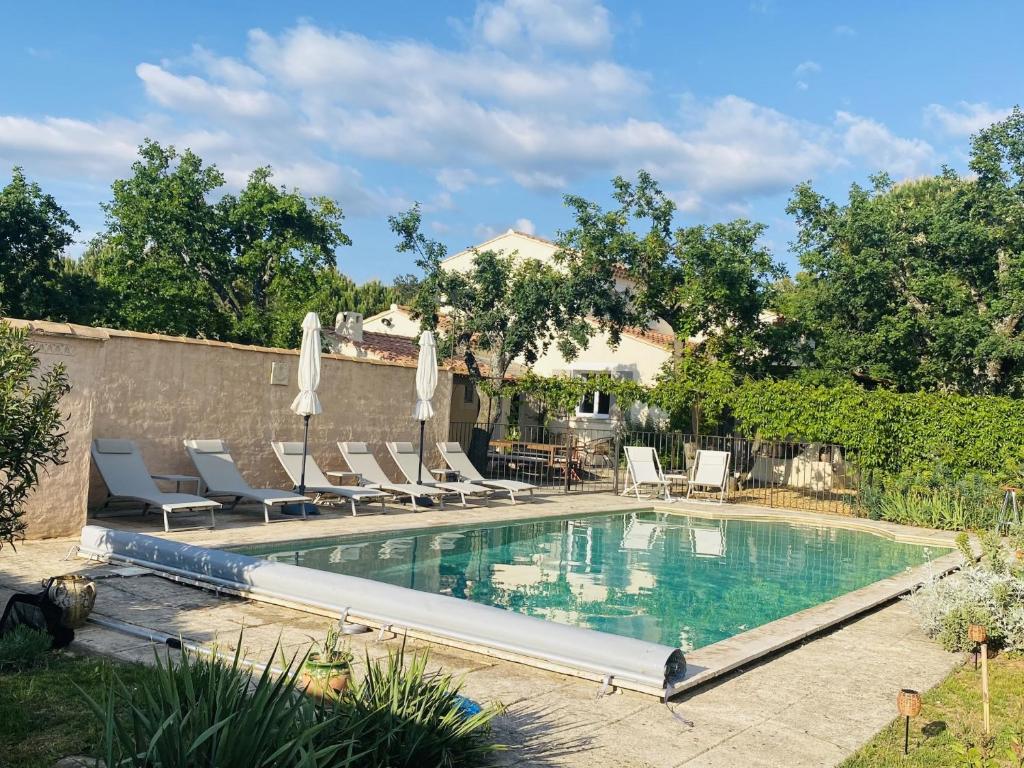 - une piscine avec des chaises longues et des parasols dans l'établissement Villa Les Chênes, à Mirabel-aux-Baronnies