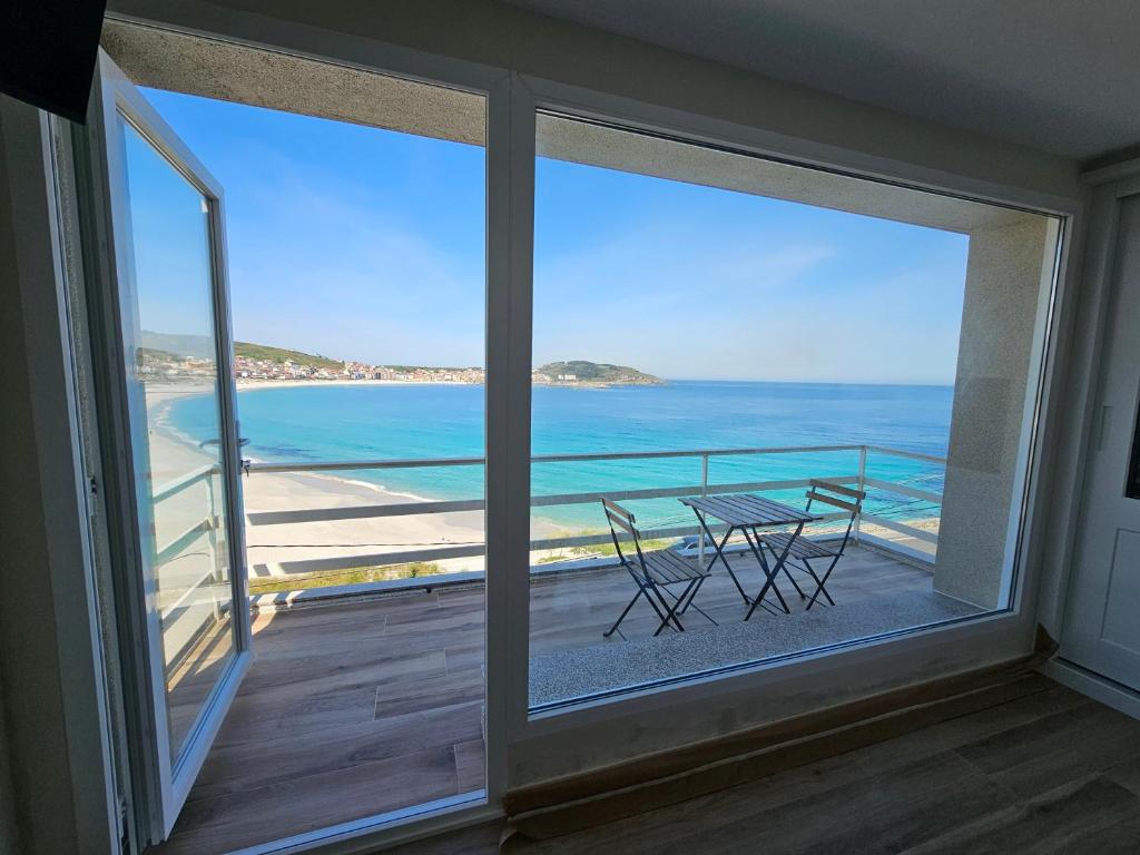 a balcony with a table and a view of the ocean at Casa Peñascales -Laxe- Costa da Morte in Laxe