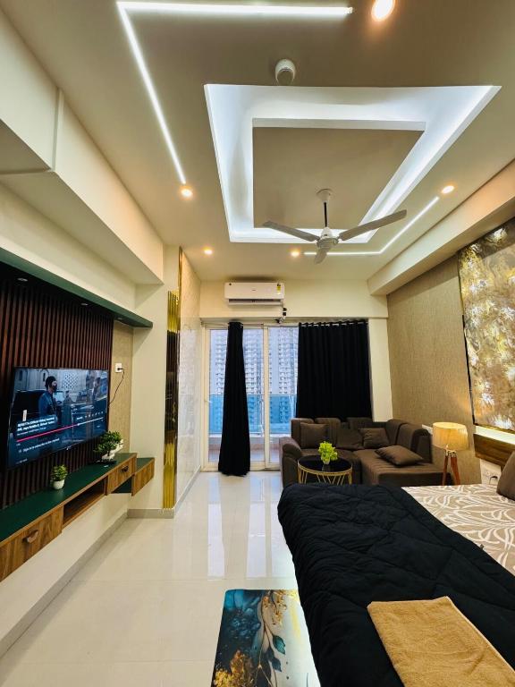 a living room with a bed and a tv at Velvet Vista in Ghaziabad