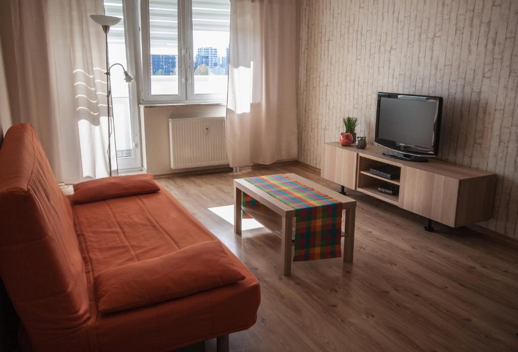 a living room with a couch and a tv and a table at Velvet Łucka in Warsaw