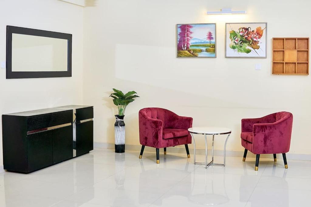due sedie rosse e un tavolo in una stanza di The fabulous appt with pool in Virage Yoff Dakar a Dakar