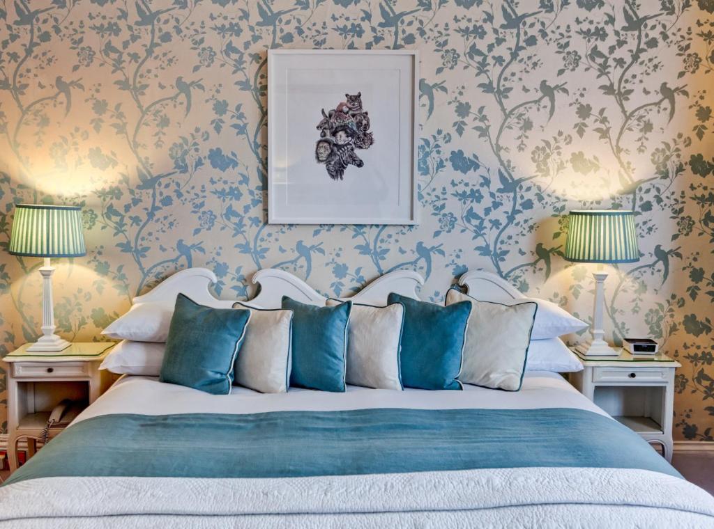 1 dormitorio con 1 cama con almohadas azules y blancas en The Claremont, en Brighton & Hove